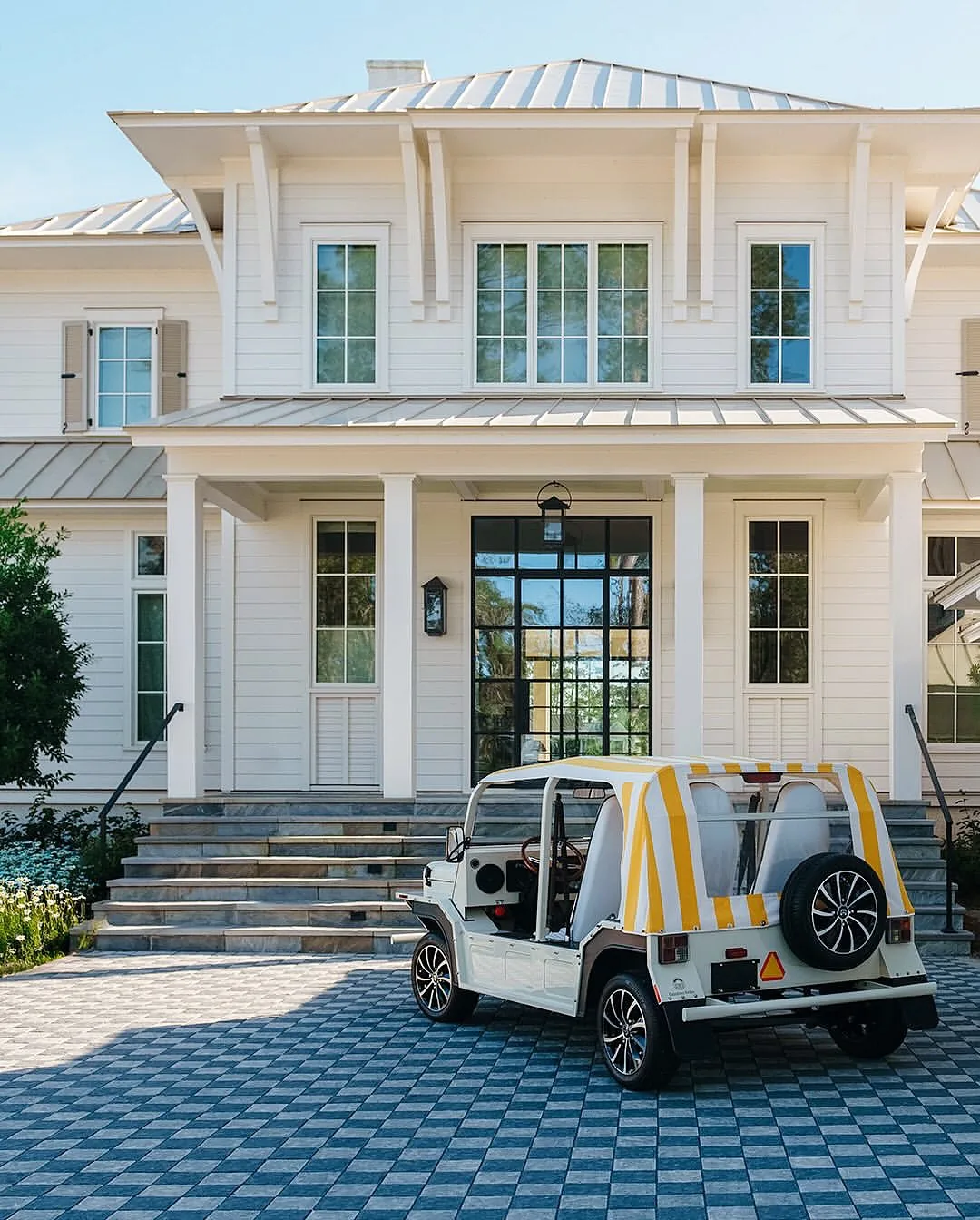 White lowcountry house with a metal roof and porch columns
