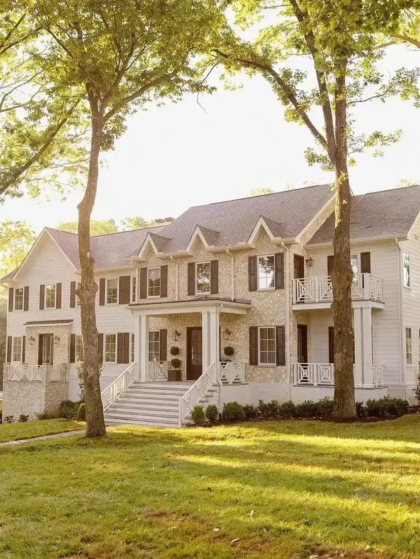 Shingle house with black shutters in warm golden evening light