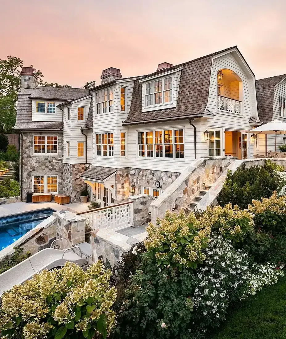 Shingle style mansion with stone terrace and swimming pool