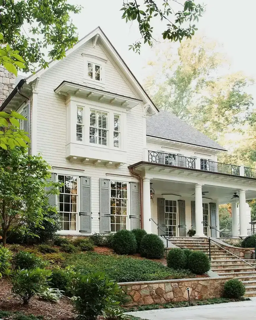 White clapboard house with columned porch and wide stone steps