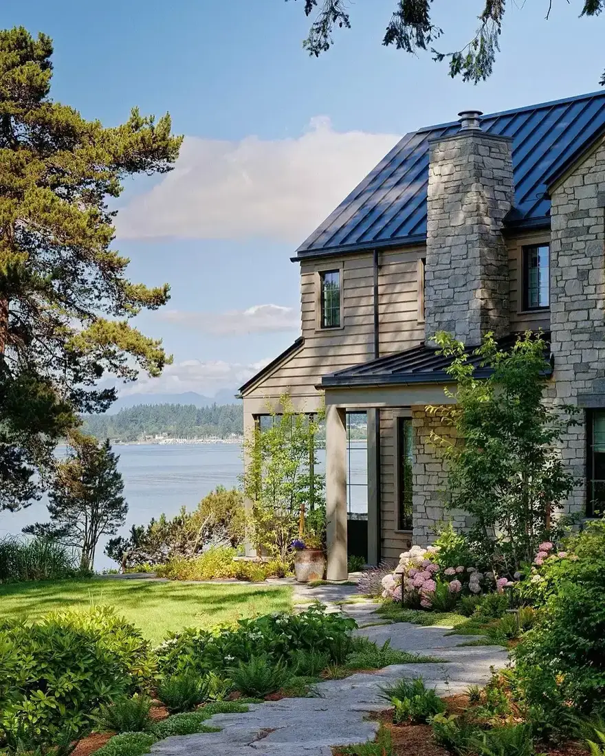Modern farmhouse with mixed stone base and layered front landscaping
