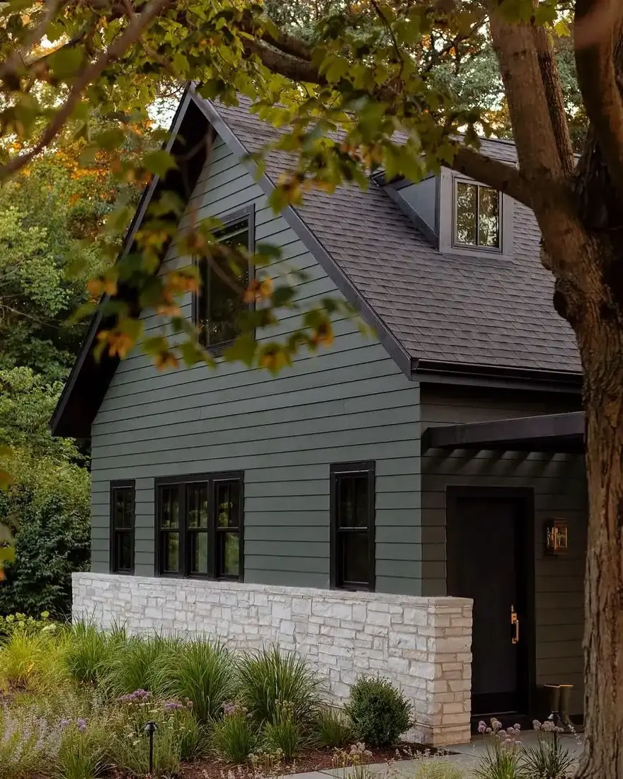 Green cottage with stone base and gable with sage cladding
