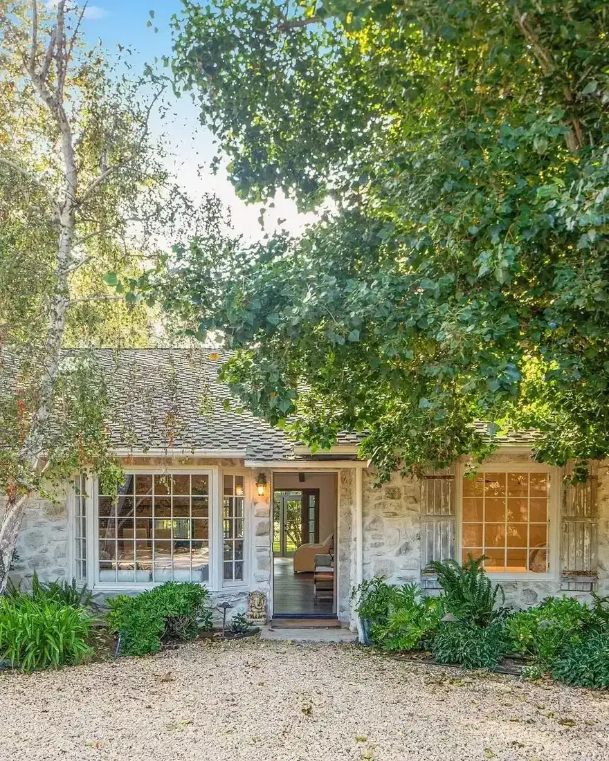 Stone cottage with gravel courtyard and clipped topiary garden