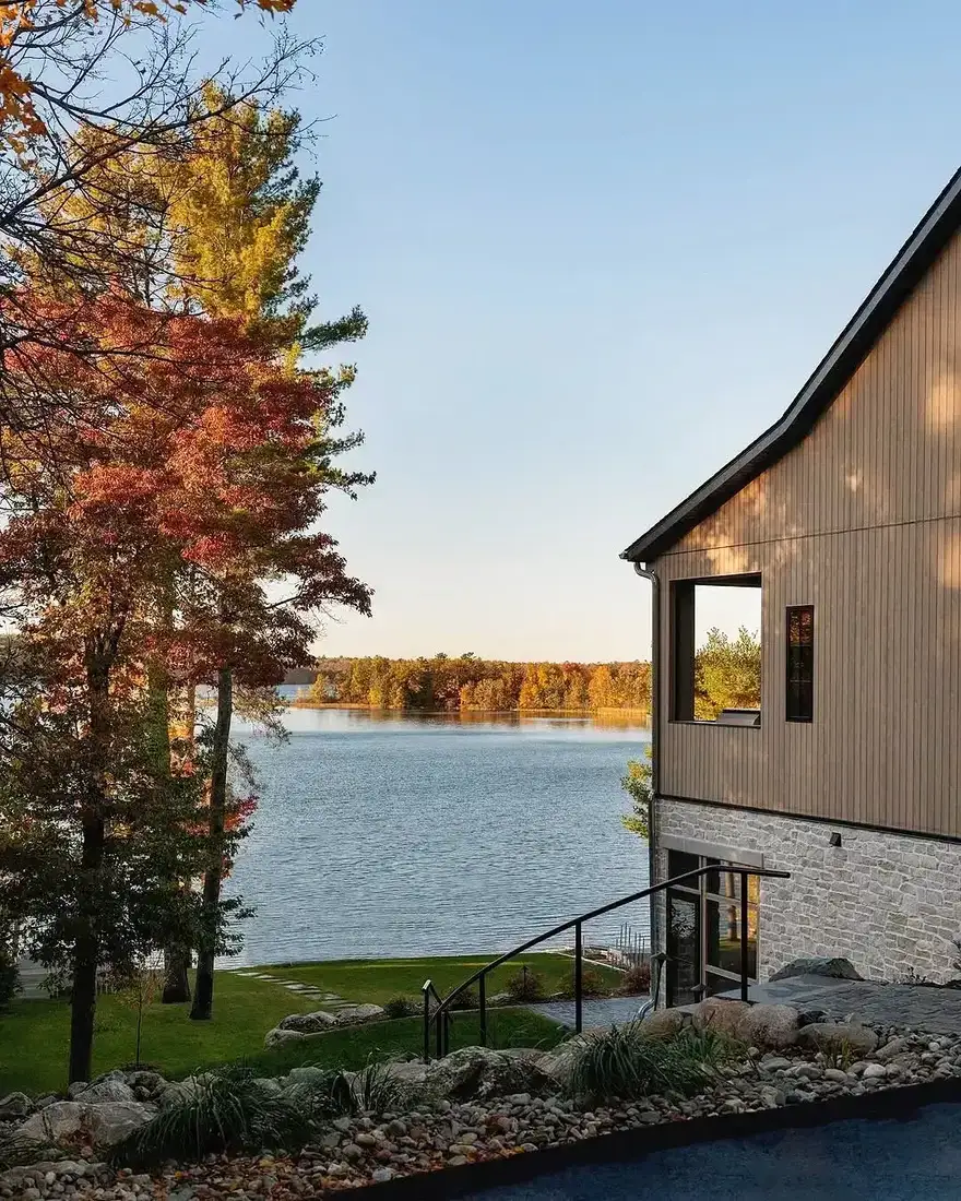 Lakeside modern house with vertical siding above a limestone base