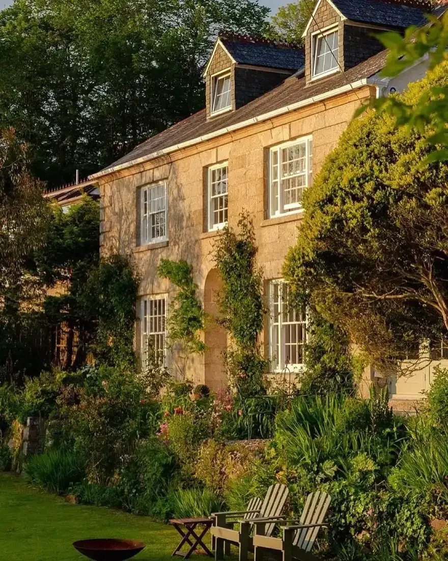 Stone Georgian house with climbing vines on trellis against limestone walls