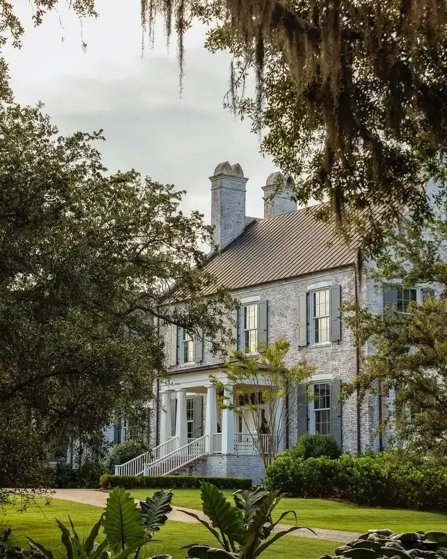 Stone manor house with Spanish moss draped oaks and wide lawn