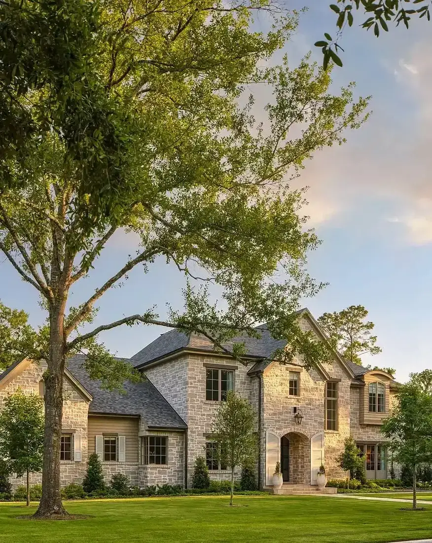 French limestone house with a deep set arched front door and pale stone surround