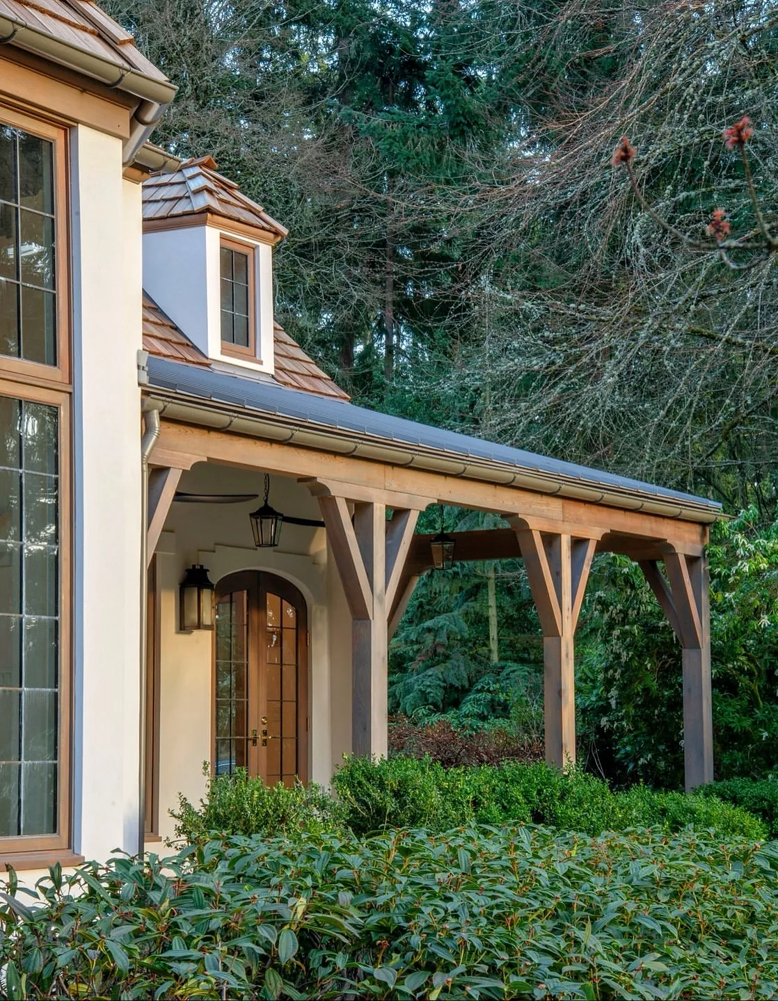 Stucco cottage with a timber porch and arched door