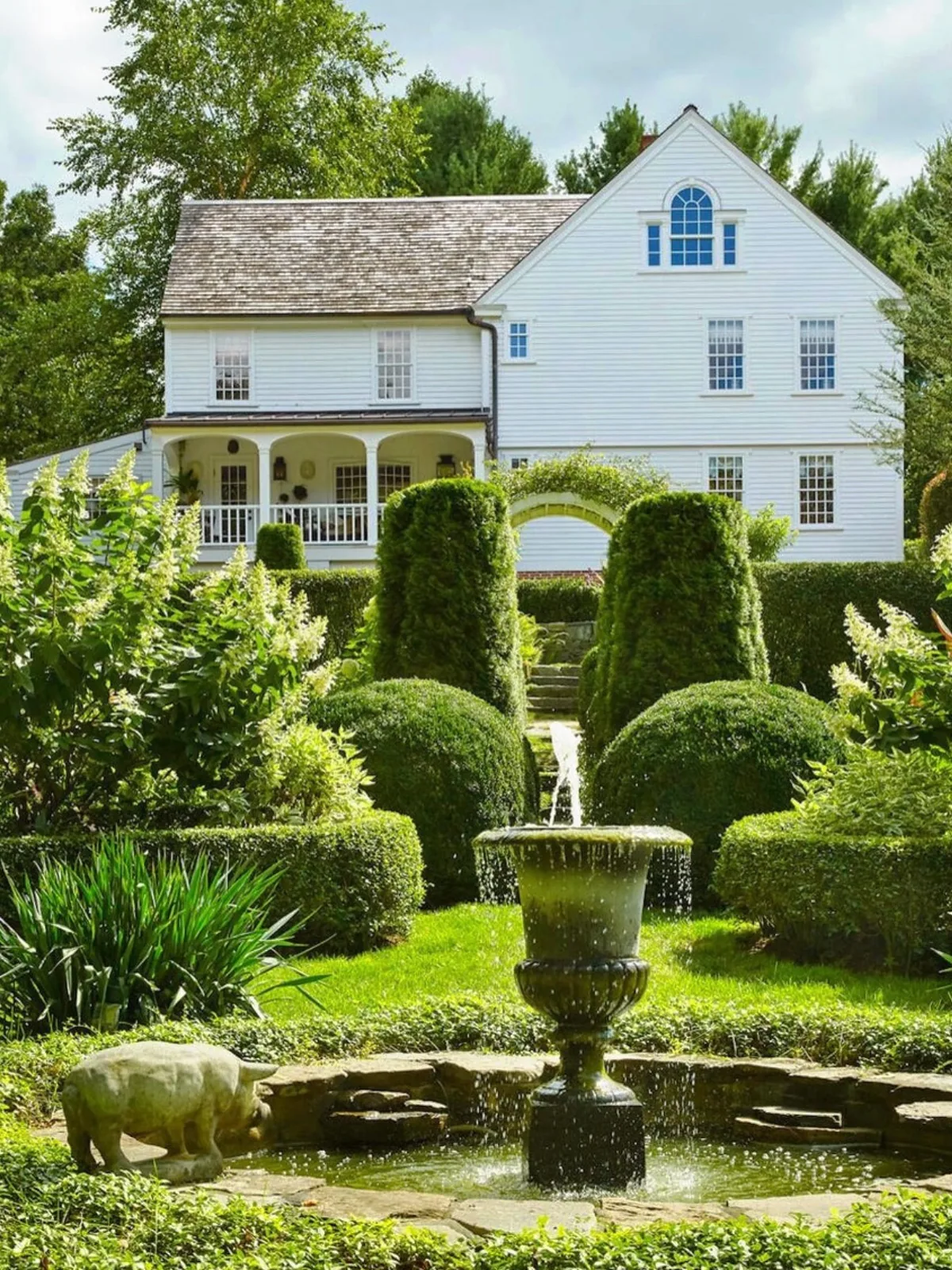 Pale blue Victorian garden with topiary and a fountain