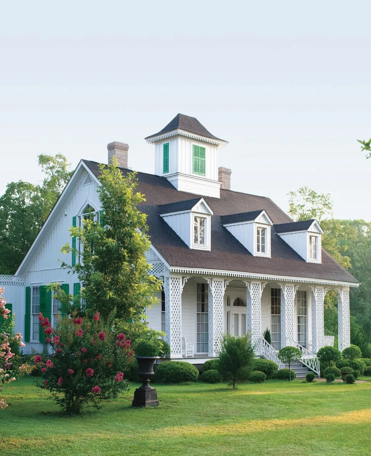 White Victorian cottage with gingerbread trim and a cupola