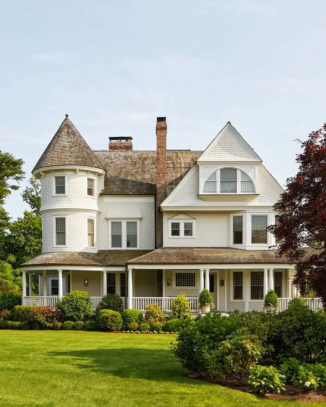 White Victorian house with a turret and wraparound porch