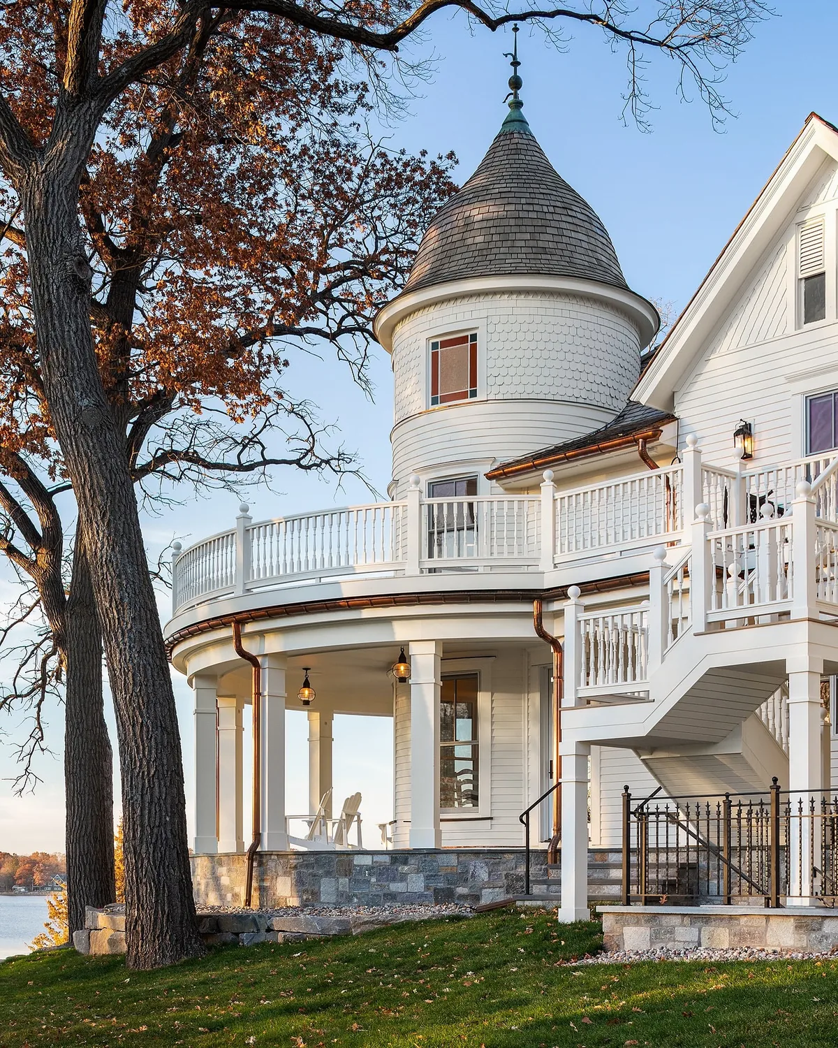 White Victorian turret house with a lake house porch