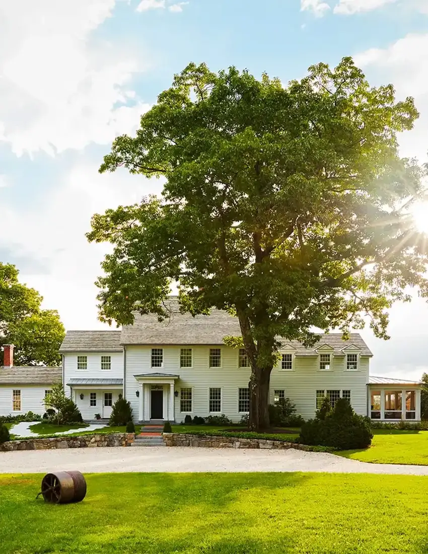 White farmhouse exterior with strong curb appeal and manicured lawn