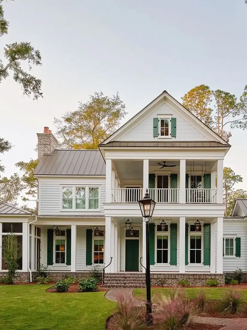 White farmhouse with a double height front porch and dark green shutters