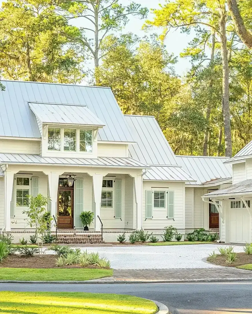 White farmhouse with standing seam metal roof and crisp white walls