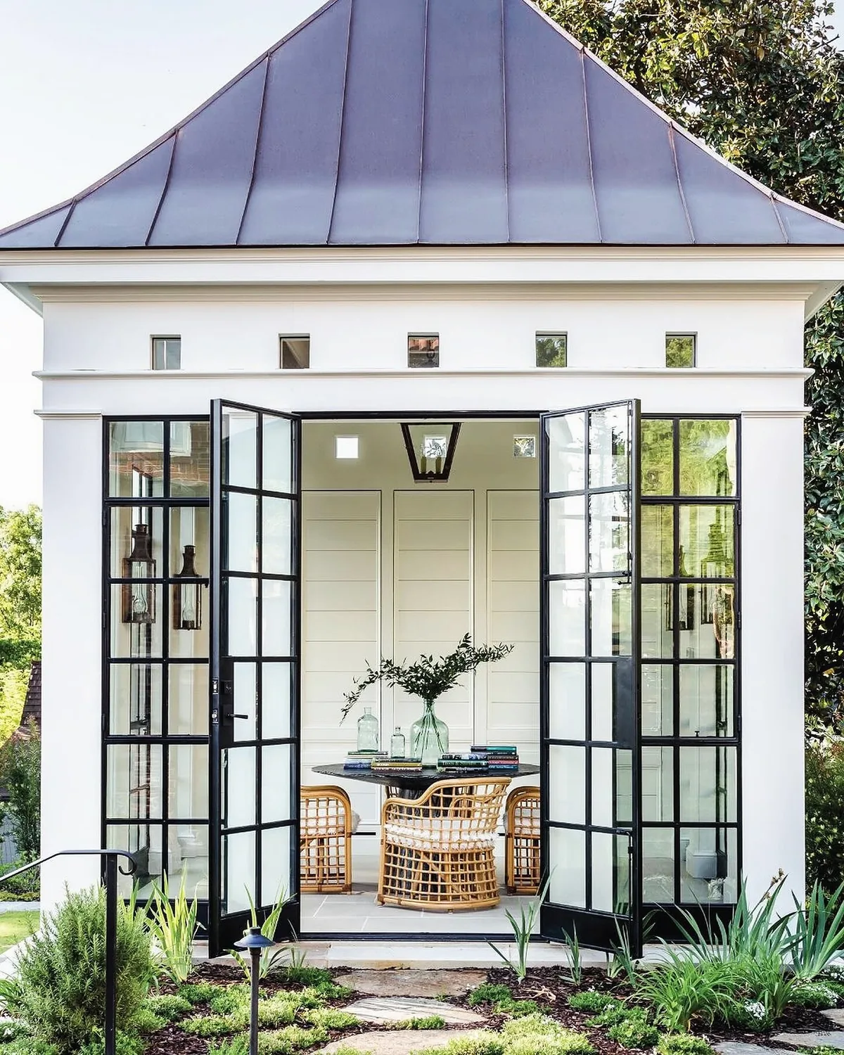 White pool house with a copper roof and doors