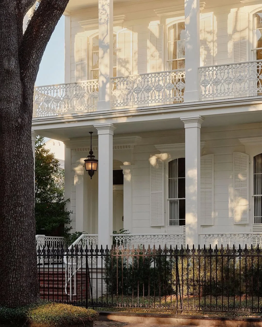 White southern townhouse with an iron fence and balcony