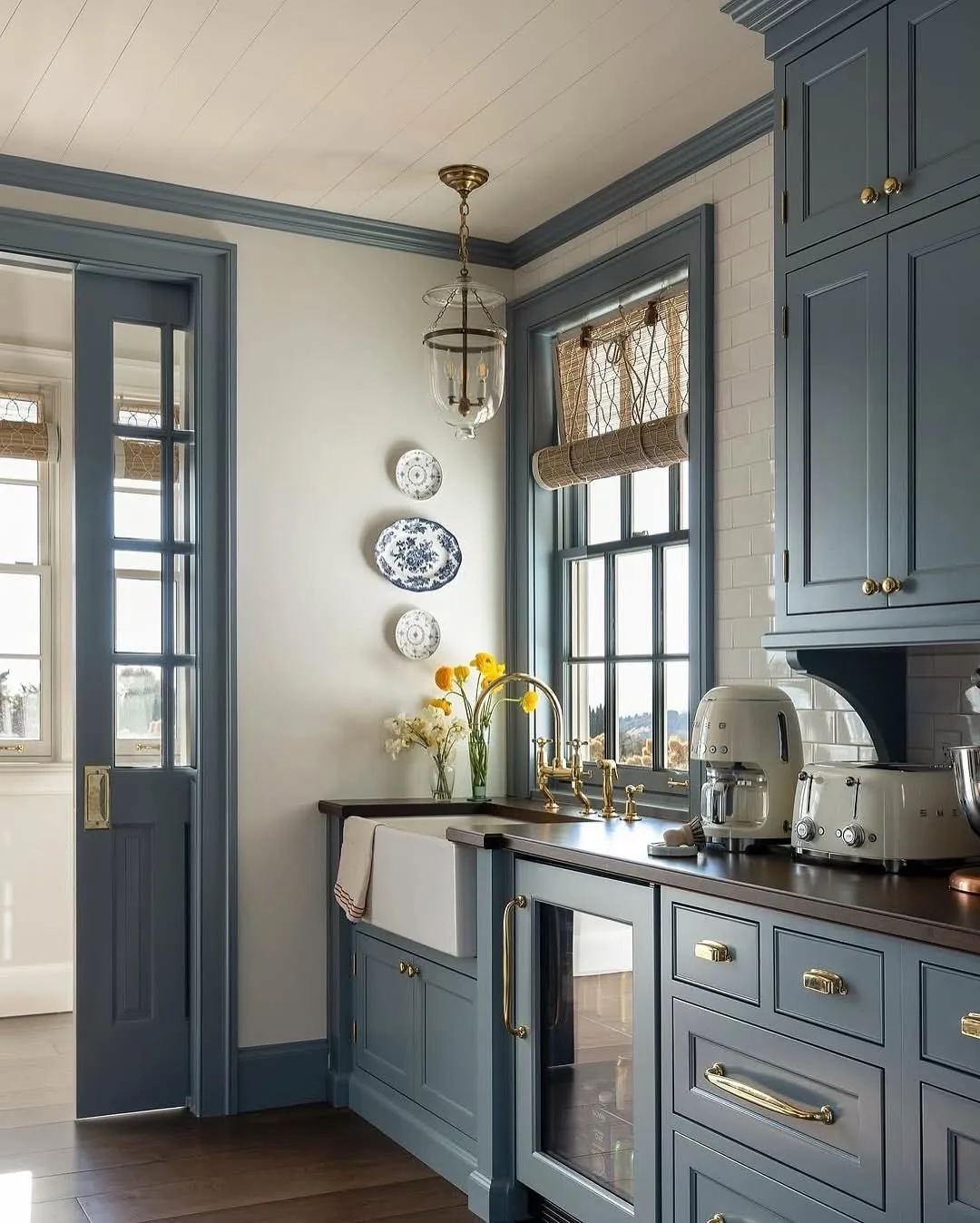 Blue gray kitchen cabinets with brass hardware