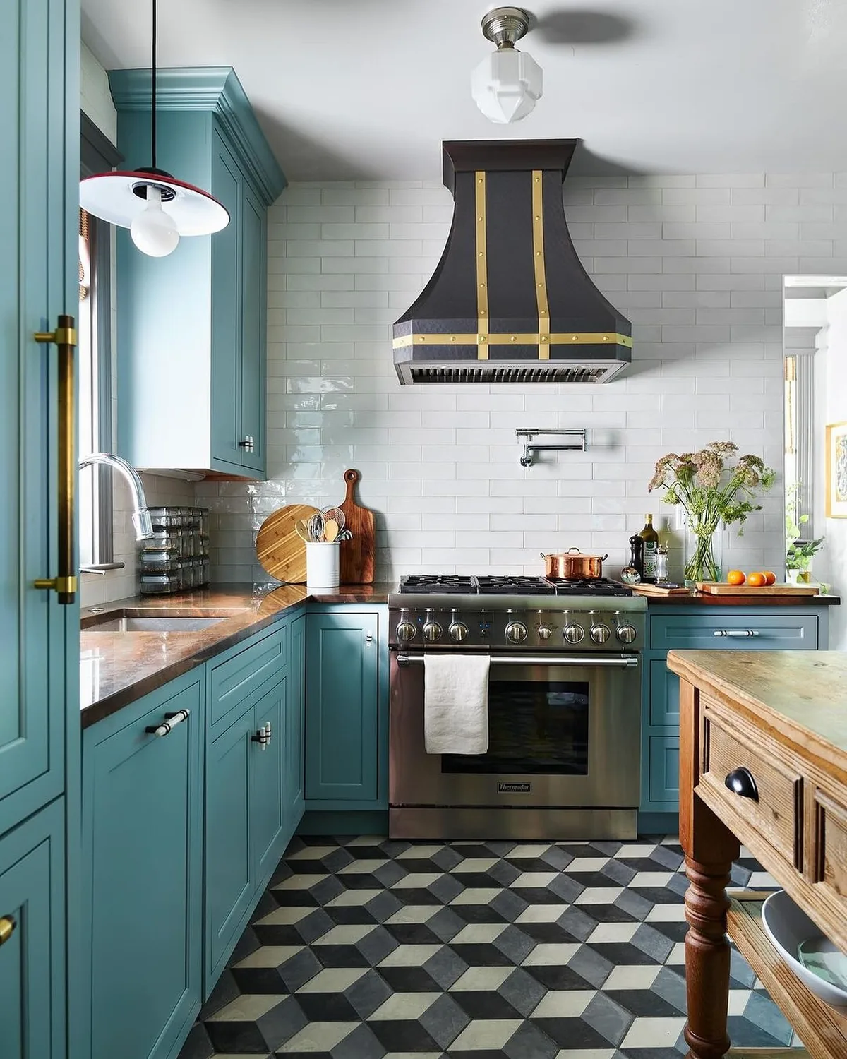 Blue kitchen cabinets with a black range hood