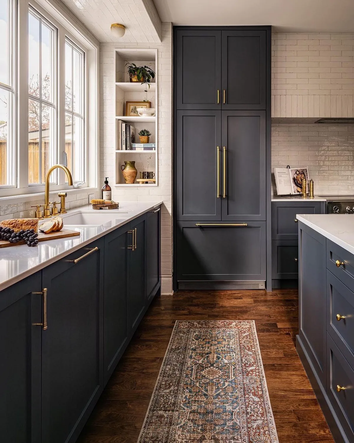 Dark blue kitchen cabinets with brass hardware