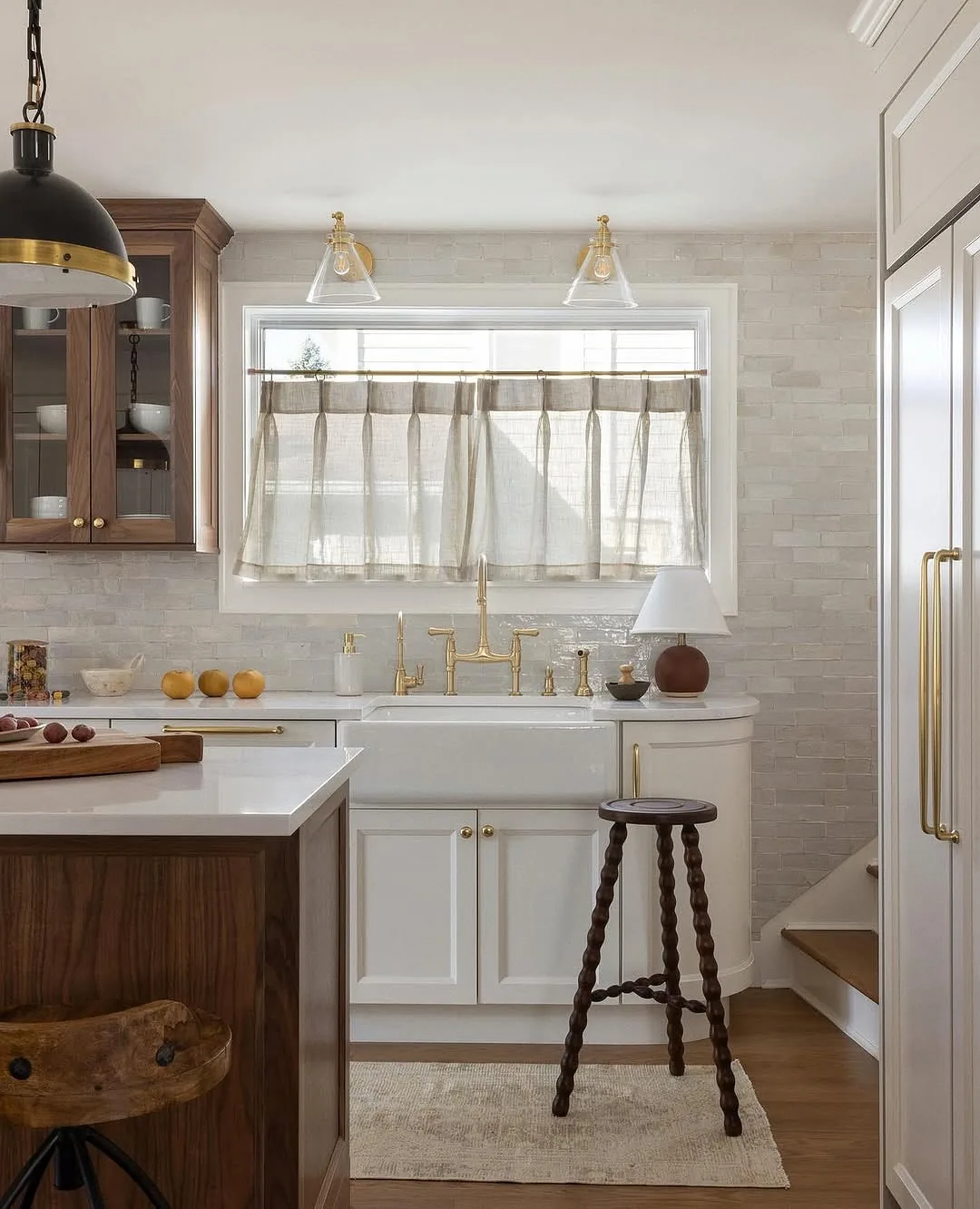 Walnut and white kitchen with cafe curtains and brass