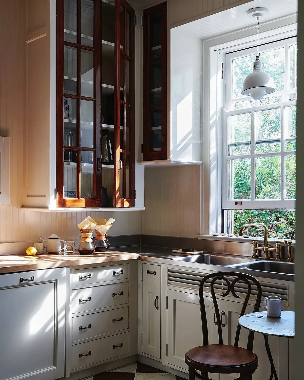 White kitchen with mahogany glass cabinets and a window