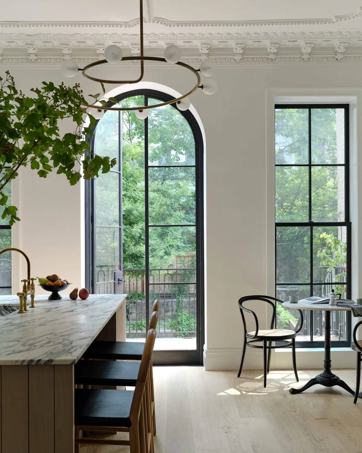 White kitchen with marble and an arched black window