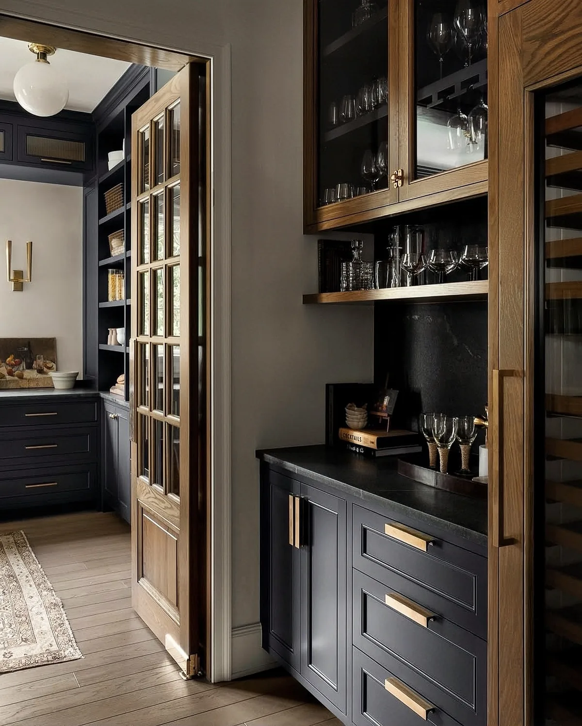 Black butler's pantry with a wine fridge and glass cabinets
