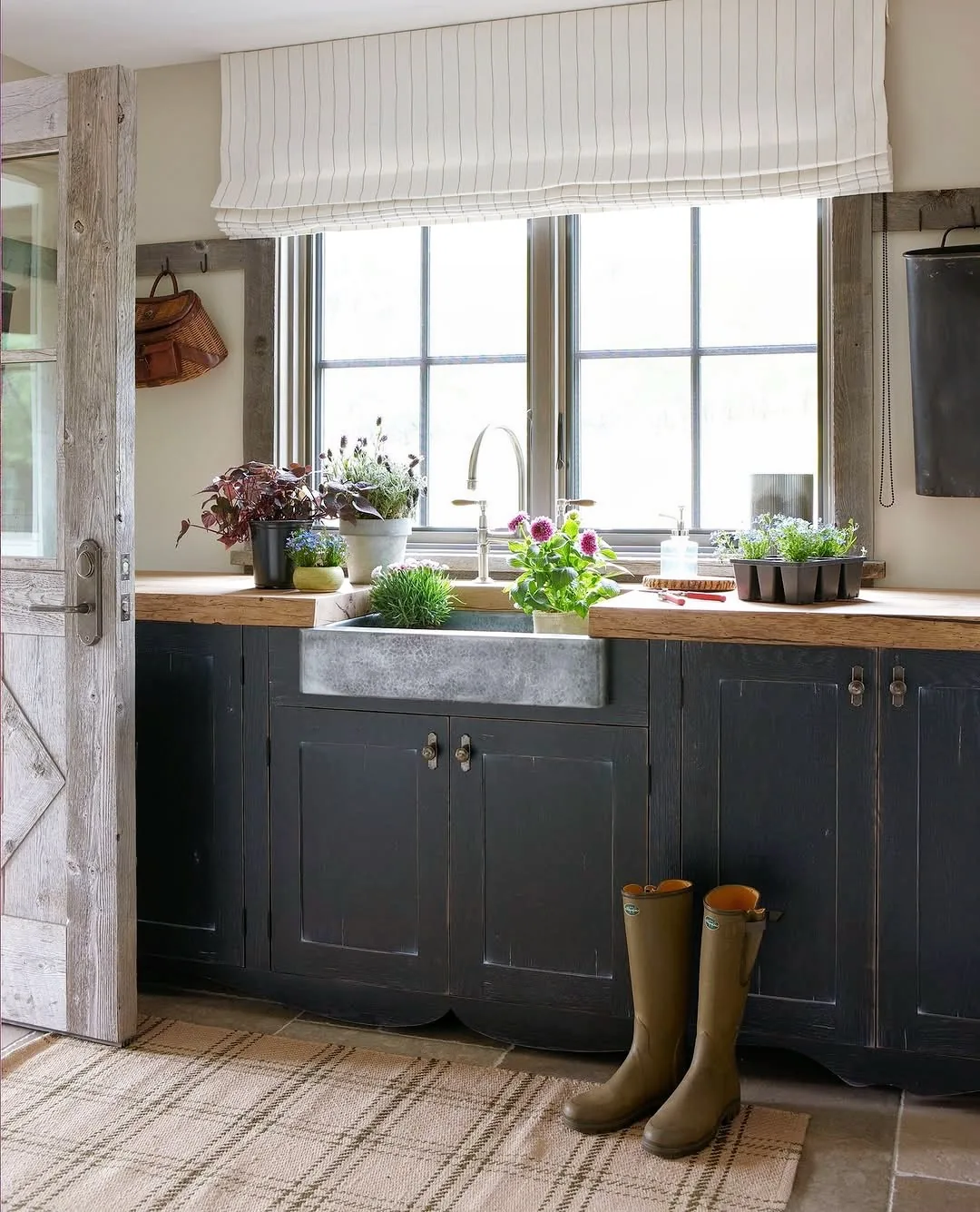 Black cabinets with a farmhouse sink and reclaimed wood