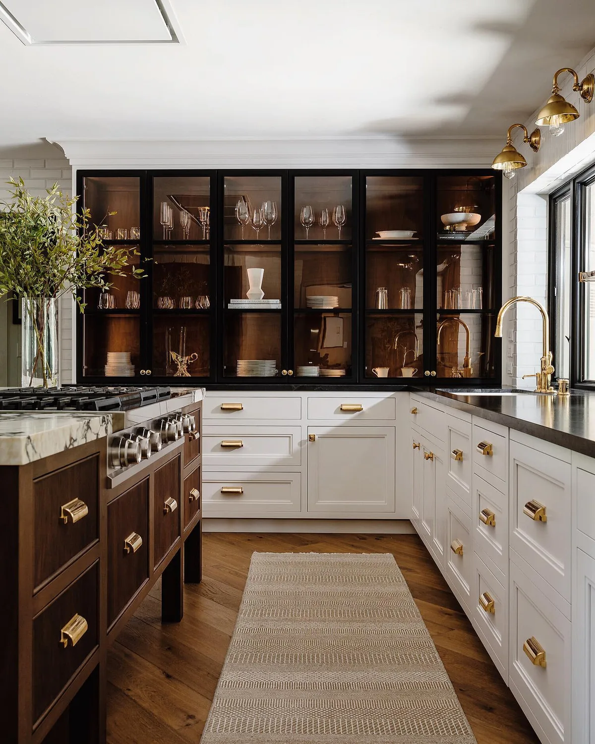 Dark wood and glass cabinets in a white kitchen