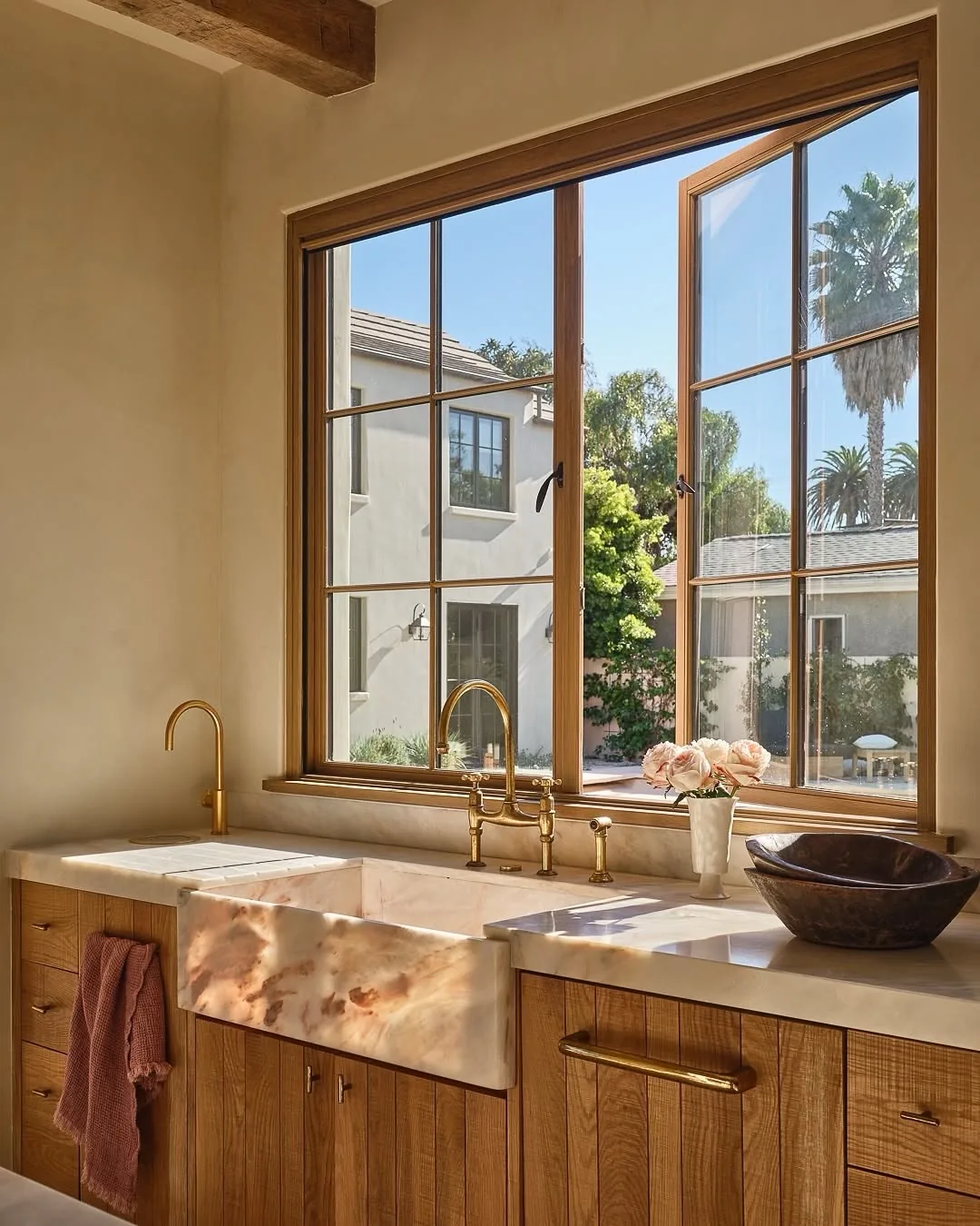 Onyx farmhouse sink with oak cabinets and brass taps
