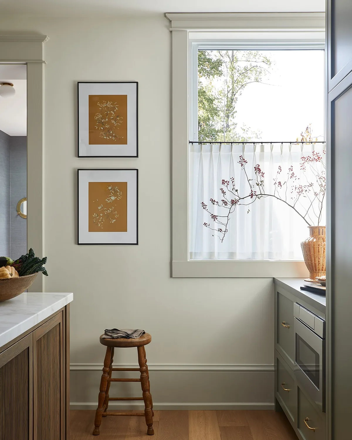 Cozy sage green kitchen nook with decorated shelves