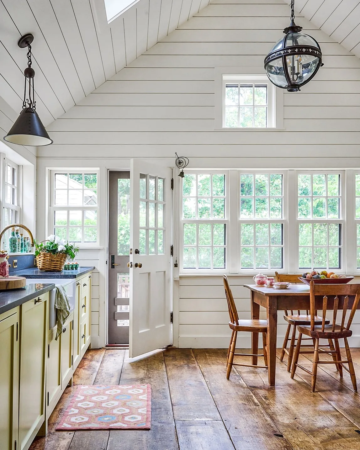 White shiplap kitchen with a vaulted ceiling and wood floor
