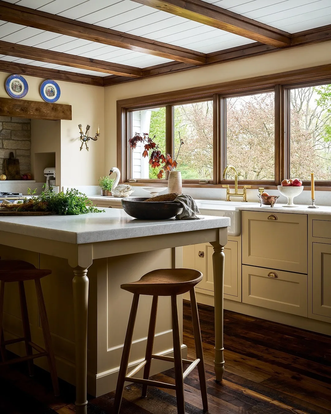 Cream kitchen with a beamed ceiling and marble island