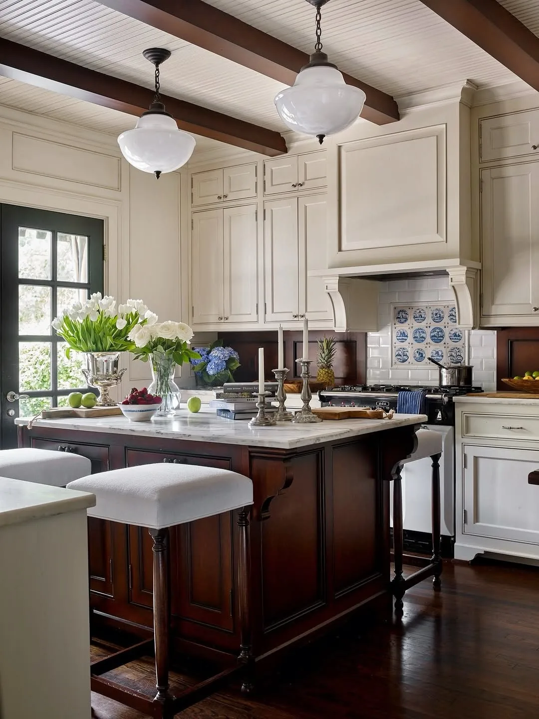 Cream kitchen with a mahogany island and Delft tile
