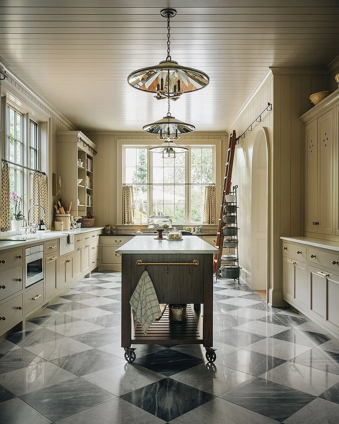 Galley kitchen with a checkered marble floor and ladder