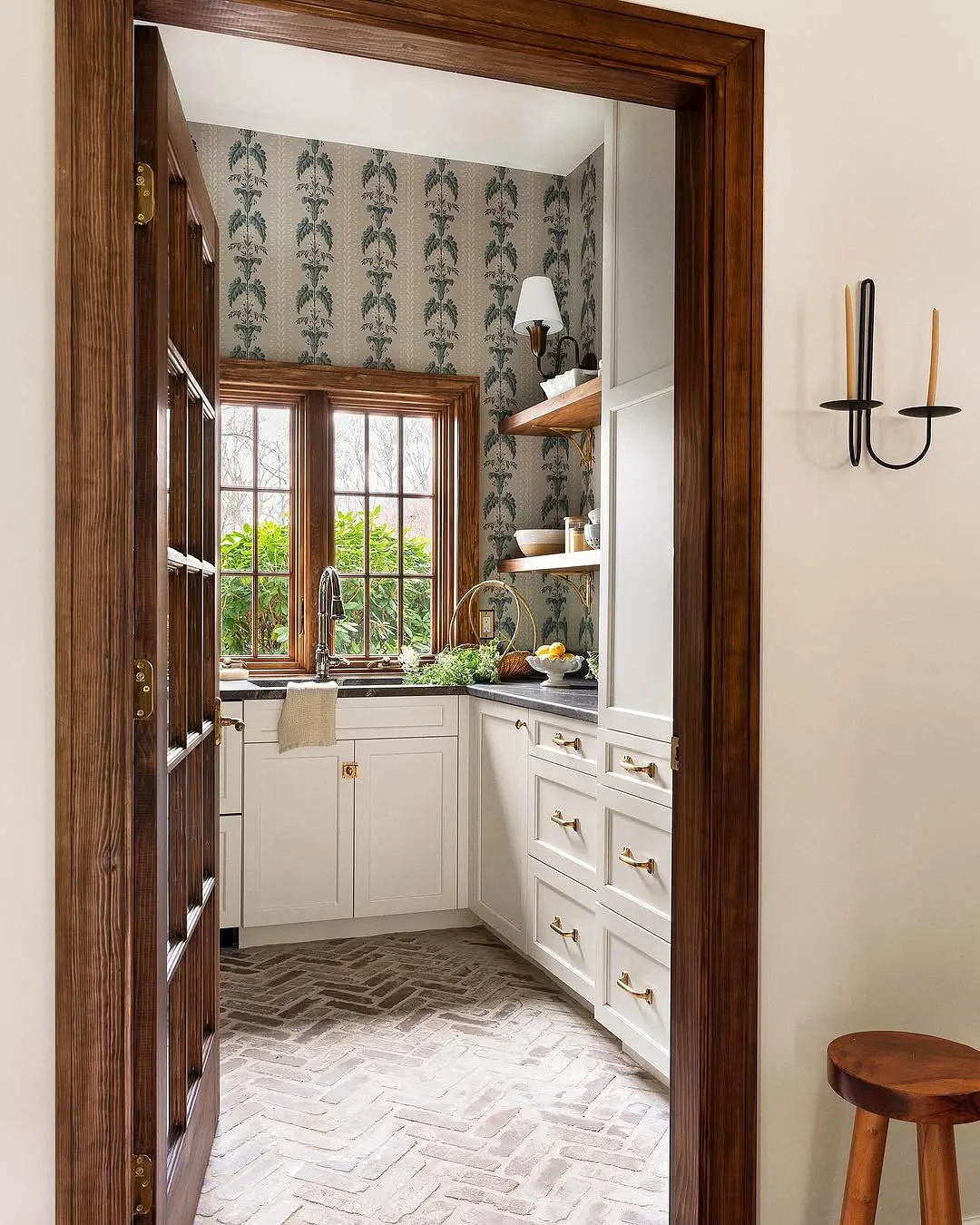 White kitchen cabinets with botanical wallpaper
