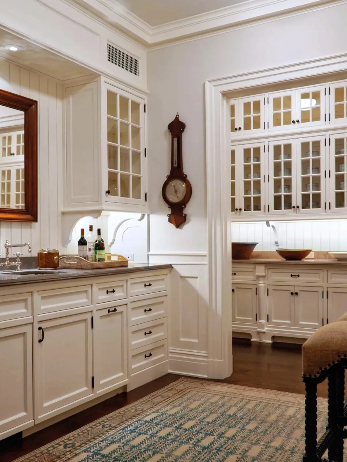 White kitchen with a glass cabinet clock