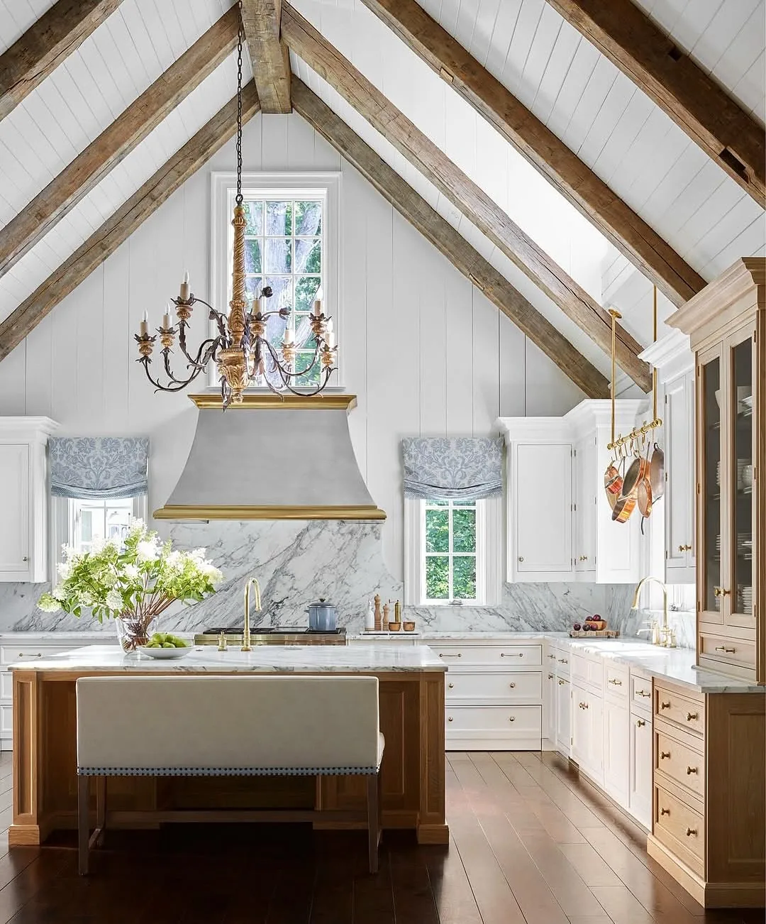 White kitchen with a vaulted ceiling and wood beams