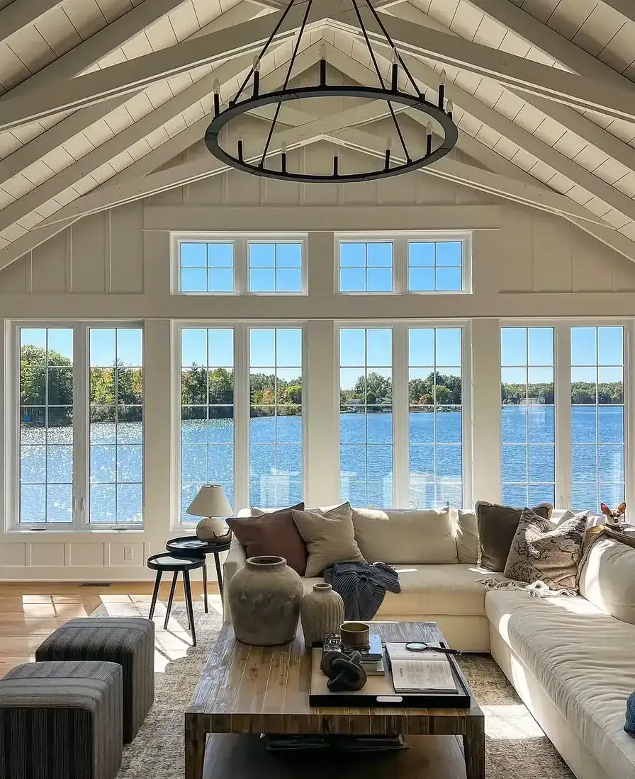 Lake house living room with tall windows, blue textiles and timber beams