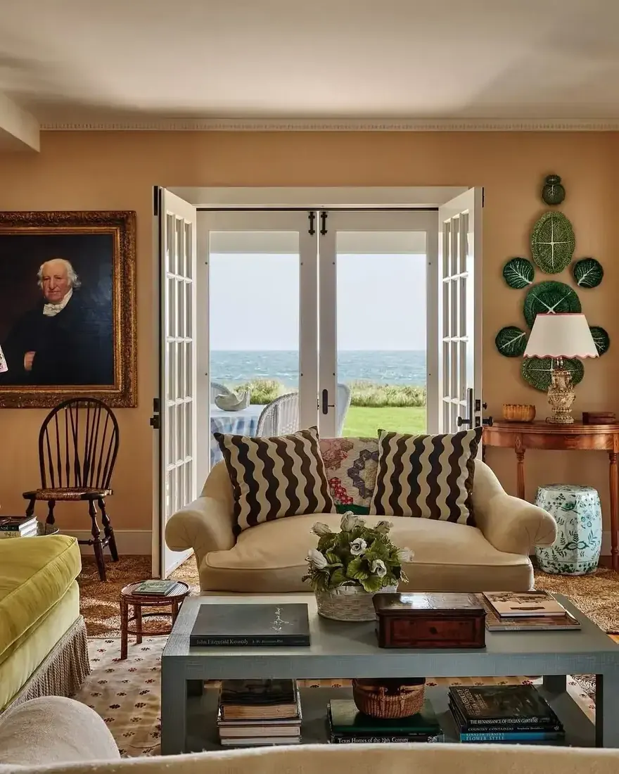 Traditional coastal living room with blue and white decor, striped sofa and layered textiles