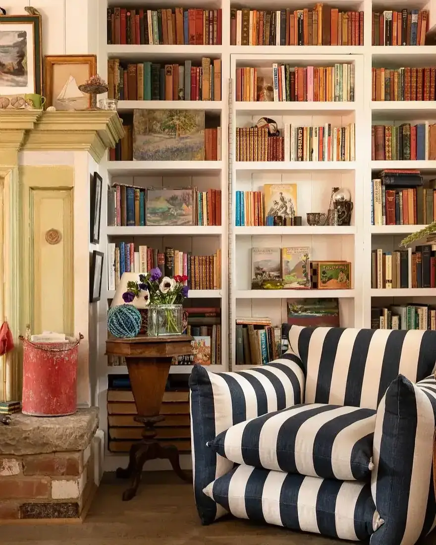Cozy striped armchair in front of built-in bookshelf decor