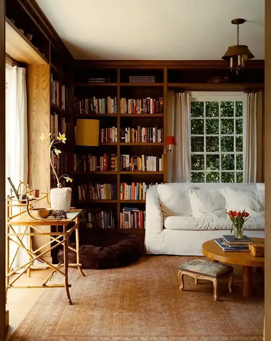 Classic white built-in bookshelves flanking fireplace in bright living room