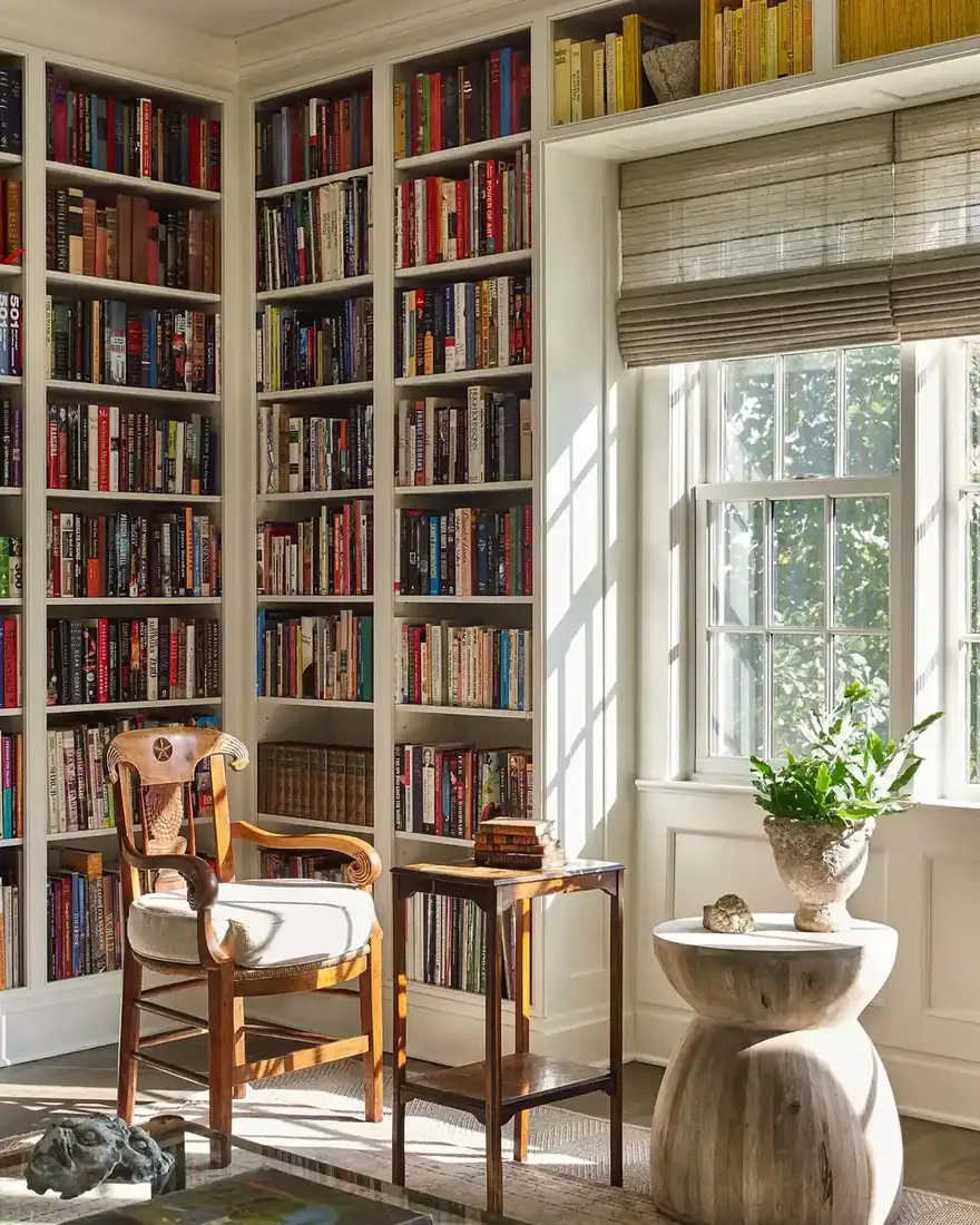 Small reading niche tucked between white built-in bookshelves