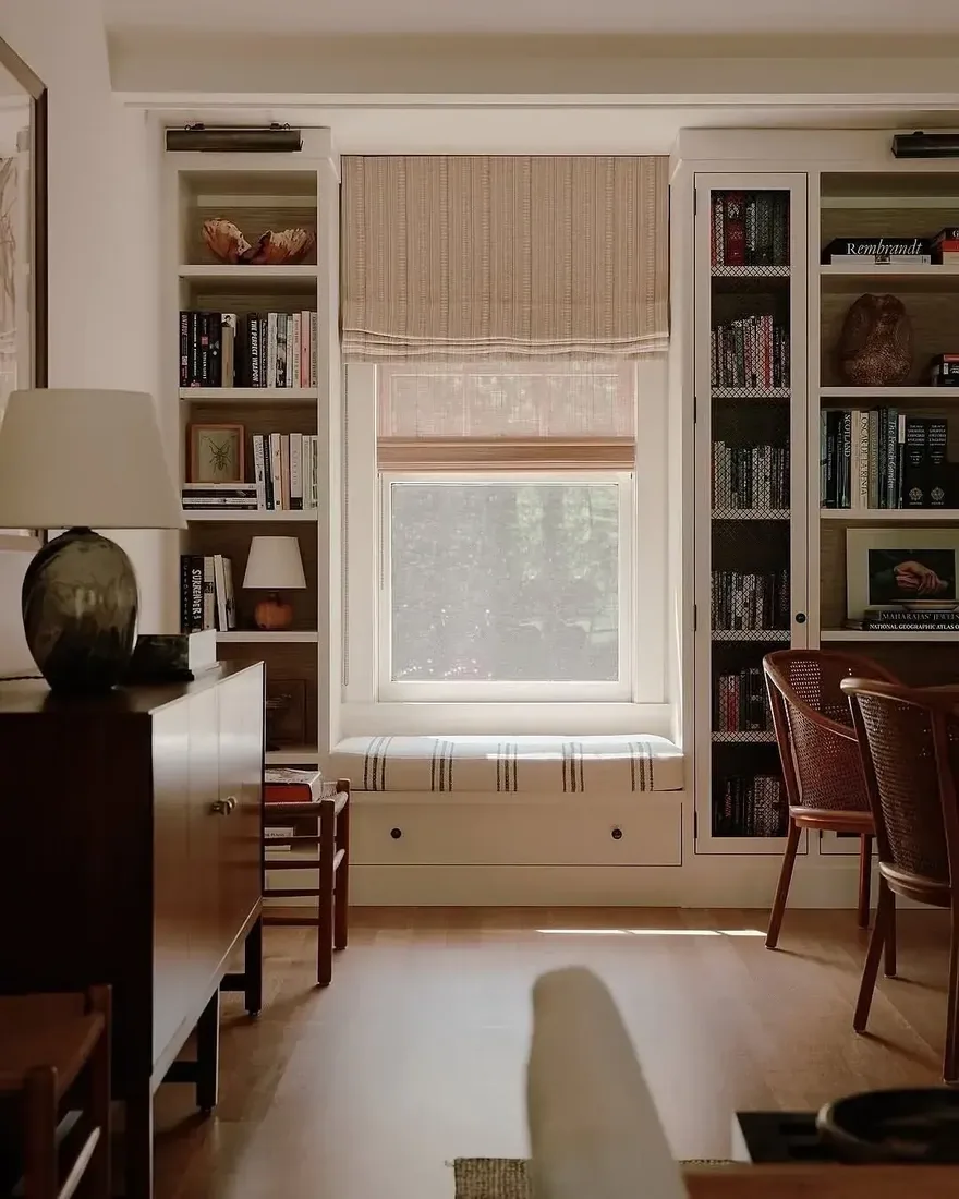 Cozy built-in bookshelves with window seat and cushions