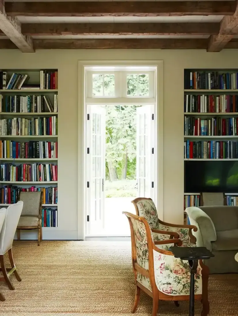 Cozy home library with French doors inside wall of bookshelves