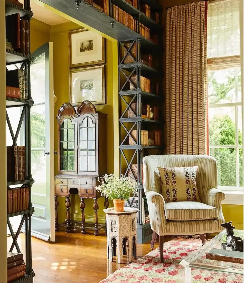 Cozy reading nook with armchair between built-in bookshelves and window light