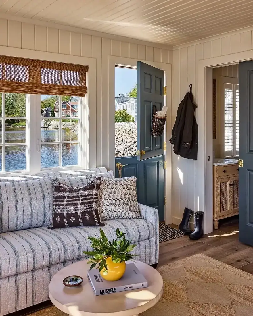 Cottage coastal living room with blue and white decor, timber beams and soft light