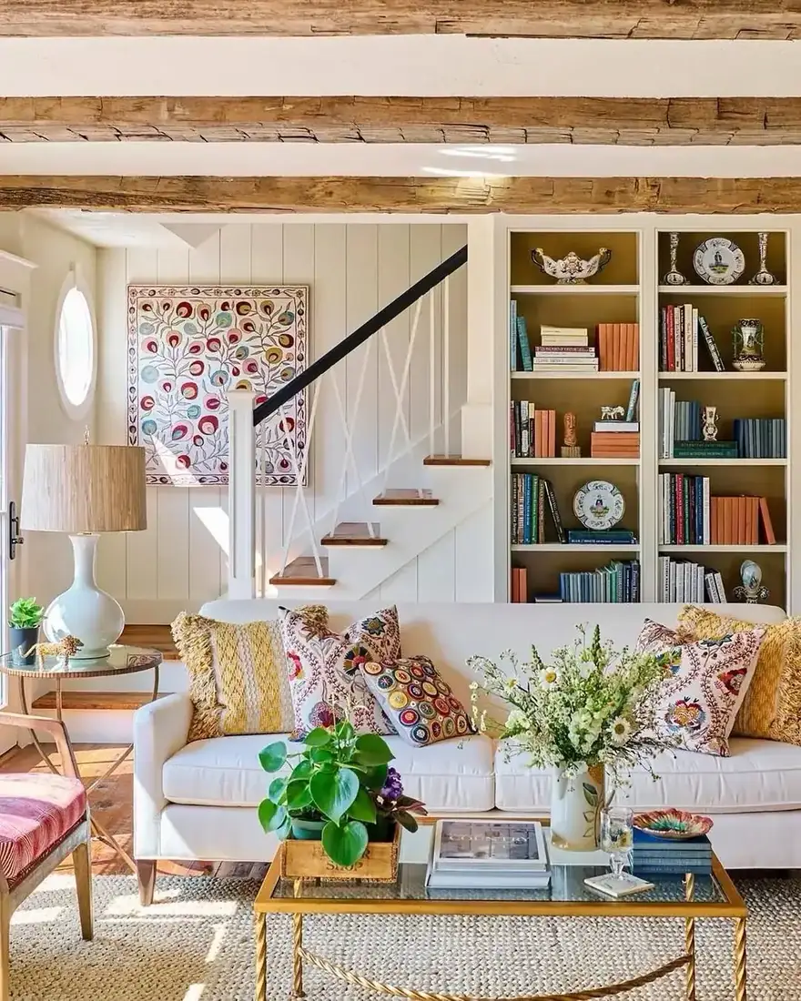 Coastal cottage living room with exposed beams, white walls and blue accents