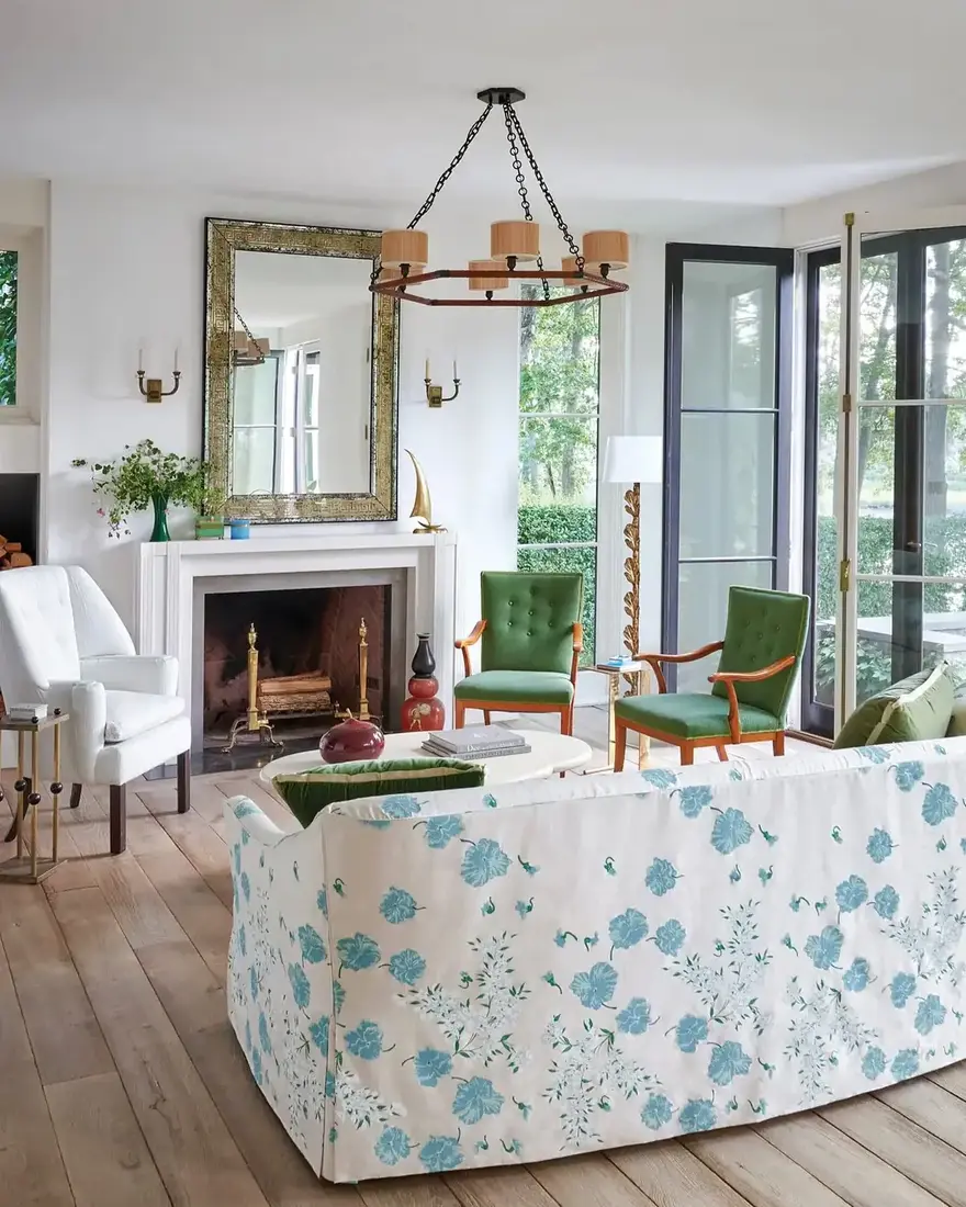 English cottage living room with blue floral skirted sofa, layered textiles and warm light